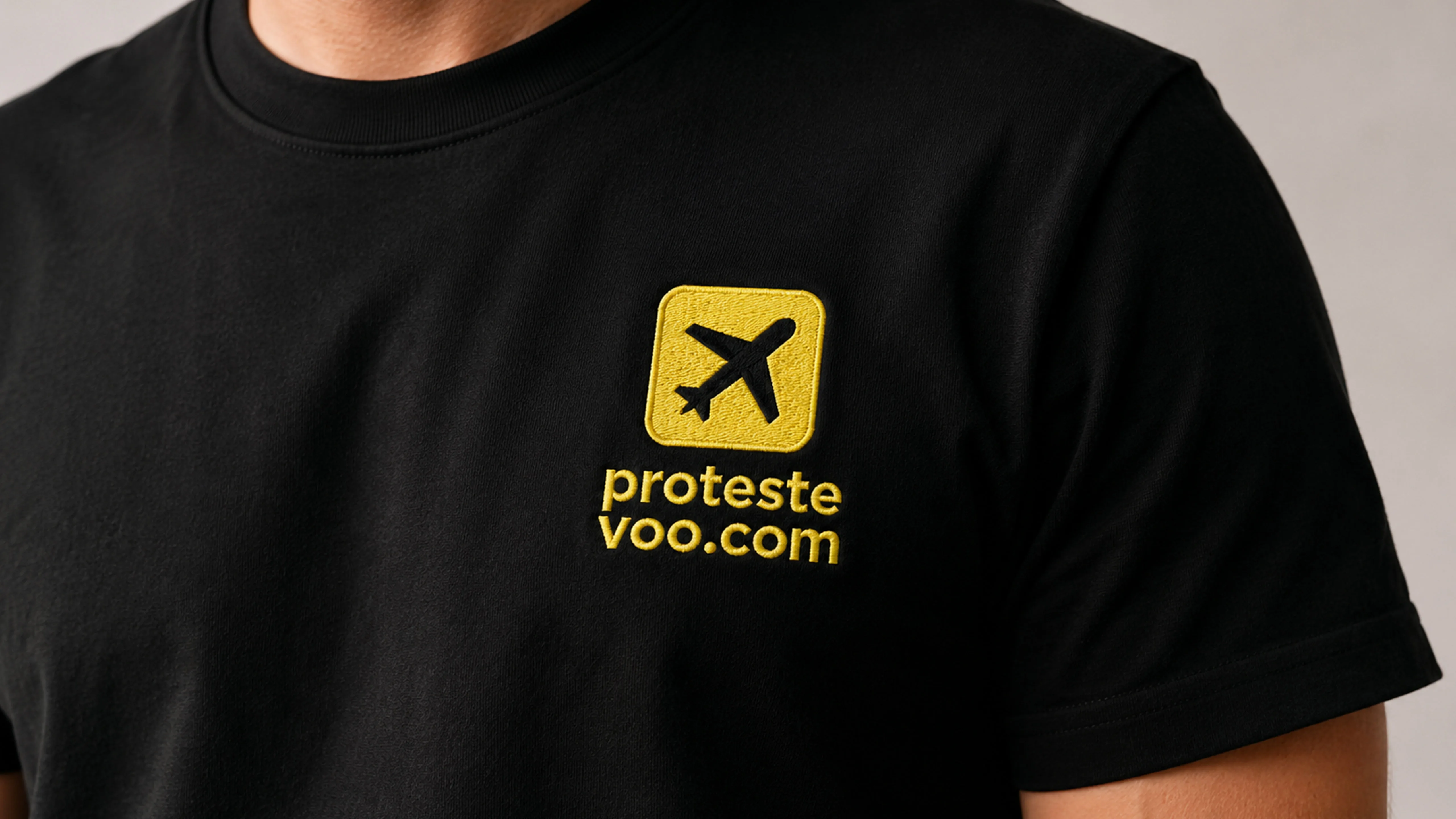 Close-up of an embroidered ProtesteVoo.com logo patch on a black T-shirt.